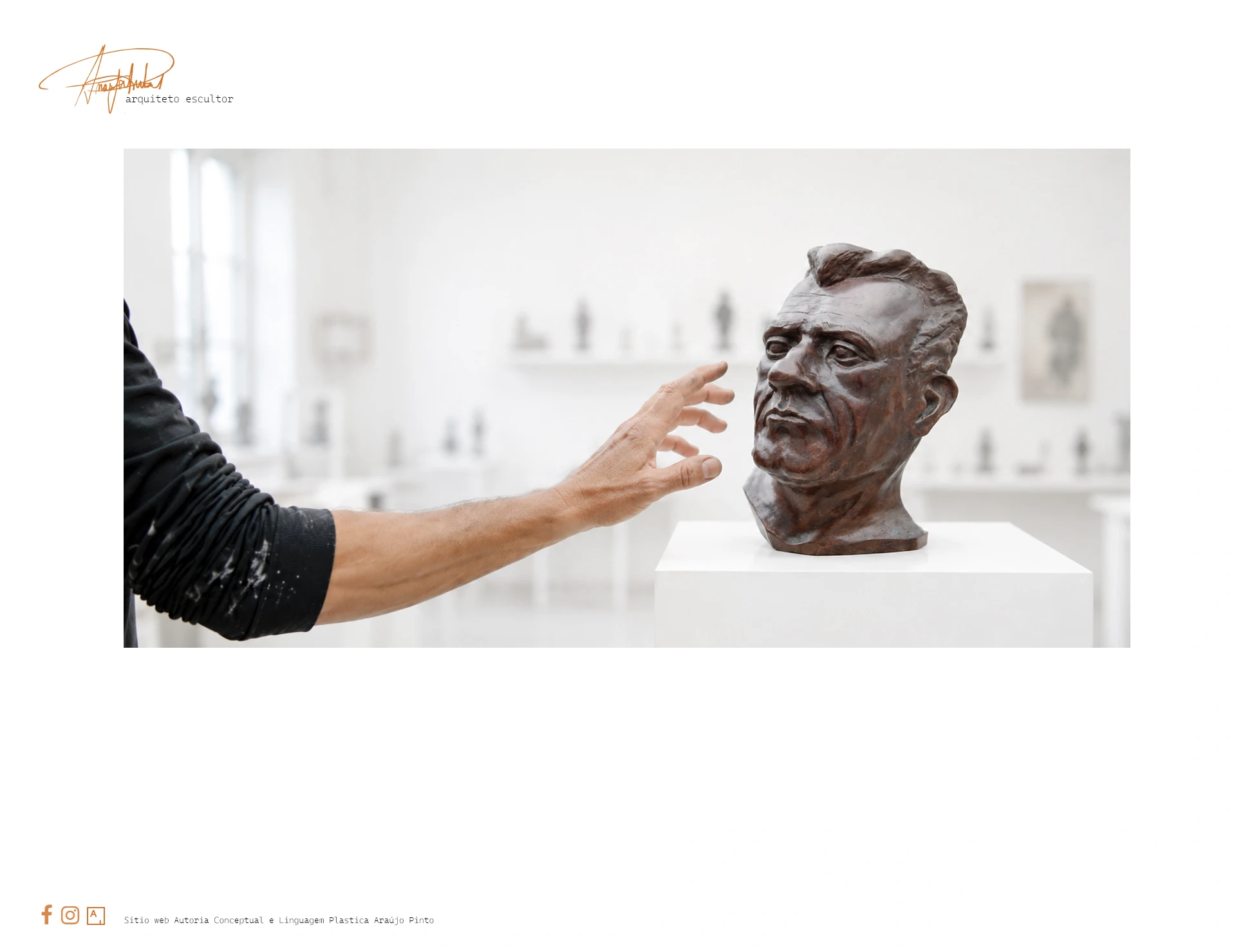 Araújo Pinto aproxima a mão de um busto escultórico num atelier branco